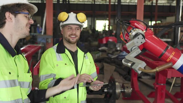 Factory worker working with adept robotic arm in a workshop . Industry robot programming software for automated manufacturing technology .