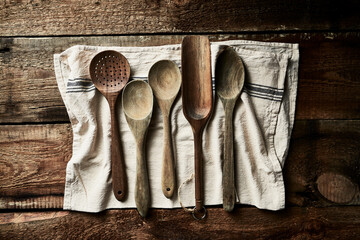 Rustic wooden spoons on linen tea towel. Flat lay