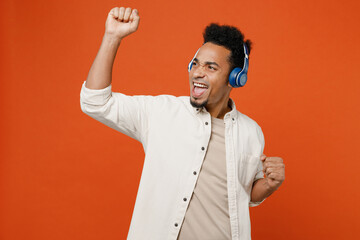 Young fun man of African American ethnicity wear light shirt casual clothes headphones listen to...