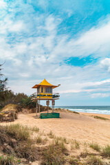 Yellow lifeguard tower on the sandy beach, overlooking the Pacific Ocean on the Gold Coast in Australia.