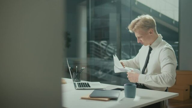 Engineer Bursting with Joy Reviewing Documents. Successful Man Making Profitable Deal and Celebrating the End of the Project.Young Smiling Architect Scatterring Papers around Him Waving Fists Happily