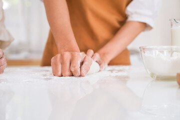 Fototapeta na wymiar Woman kneading dough on the table.
