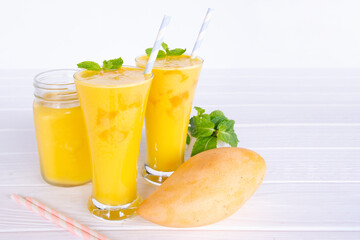 Mango smoothies yellow colorful fruit juice milkshake blend beverage healthy high protein the taste yummy In glass,drink to lose weight drink episode morning on white gray background.