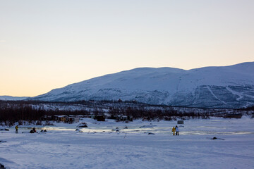 Abisko in Lapponia in Svezia. Tramonto al lago di Tornetrask ghiacciato. Sole, neve, ghiaccio, al circolo polare artico, un paesaggio del nord Europa