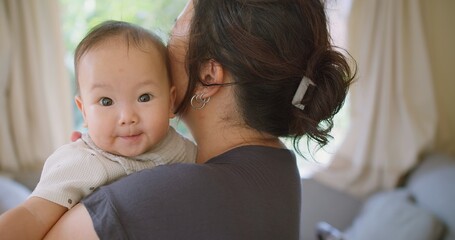 Close up portrait young mother hold in arms hug cuddle little baby girl cute little infant toddler, loving Asian mom hug embrace small baby child, relax enjoy tender family moment Motherhood concept