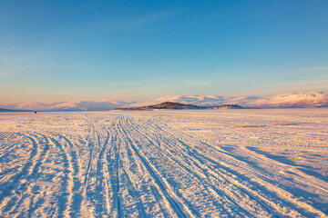 Abisko in Lapland in Sweden. Sunset at frozen Tornetrask Lake. Sun, snow, ice, the Arctic Circle, a landscape of northern Europe