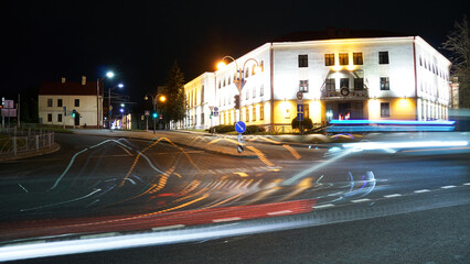 Obraz premium Night city light lines from cars. cars in highway with blur motion. Street view of the modern city at night. A lot of light from car headlights, advertising banners and night lights.
