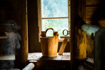 Traditional Finnish wooden sauna in details. Wooden bucket with scoop.  Old rustic interior. 
