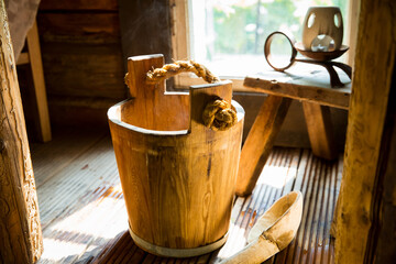 Traditional Finnish wooden sauna in details. Wooden bucket with scoop.  Old rustic interior. 