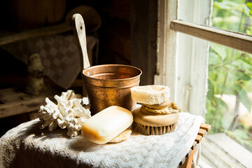 Traditional Finnish wooden sauna in details. Set of bath accessories - loofah organic sponge, natural brush and handmade soap.  Old rustic interior. 