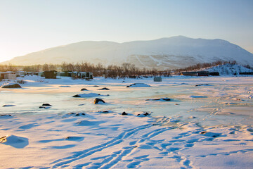 Abisko in Lapponia in Svezia. Tramonto al lago di Tornetrask ghiacciato. Sole,neve,ghiaccio,al...