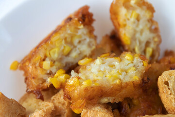 Deep fried sweet corn on white plate usually serving with peanut sweet and sour dipping sauce.