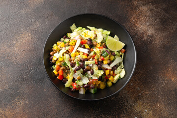 Mexican style salad of black beans, lentils, corn, tomato and lettuce with a salsa and tortilla chips