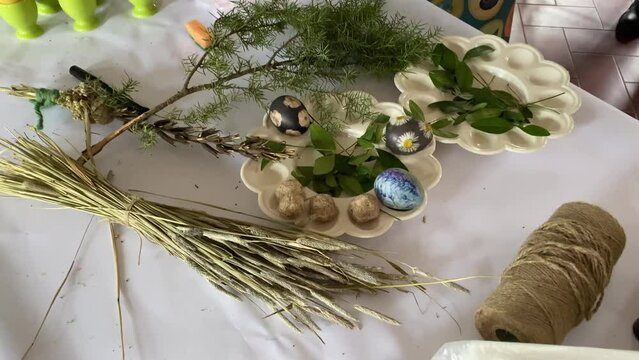 Many Easter eggs are painted with various natural dyes and a juniper branch lying nearby