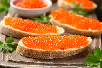 Naklejka na ściany i meble Salmon red caviar sandwiches on wooden board