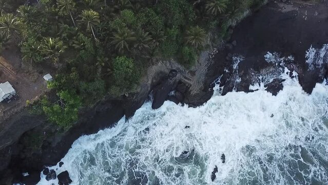 Breaking waves which hit on a rocky beach