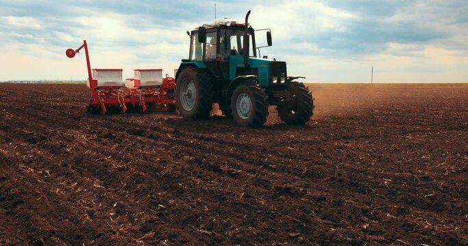 Agriculture. Tractor Seeder it Plants Seeds in the Ground in Field on the Farm. Slow motion. Tillage Equipment. 