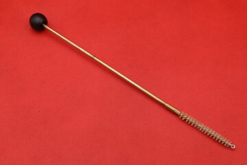 Gun cleaning tool on red background