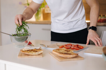 Obraz na płótnie Canvas Close-up of man put organic arugula on bruschetta. Vegan food