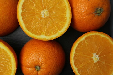a background of orange fruit eating in a cut against a gray background close-up. Season orange orange background use oranges