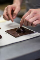 Fototapeta na wymiar Main d'un homme qui travaille du chocolat dans un atelier