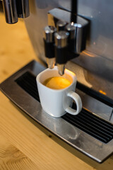 Une machine à café à grain, avec un expresso frais dans une tasse - obrazy, fototapety, plakaty