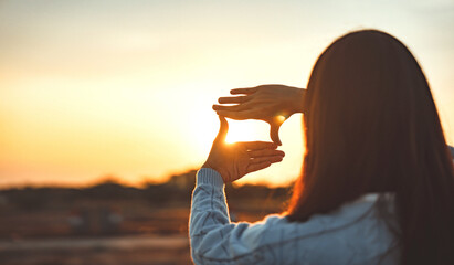 Woman hands making frame gesture with sunset, Female capturing the sunrise. Business planning,...