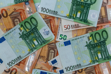 Pile of 100 and 50 euro banknotes close-up.