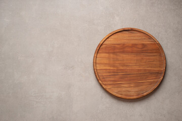 Wooden cooking board on gray concrete background, top view