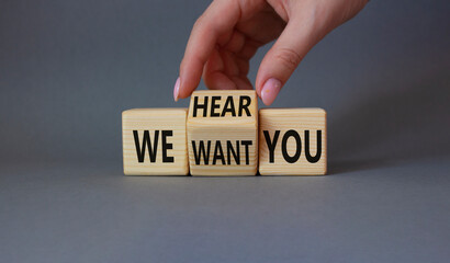 We hear and want You symbol. Businessman Hand turns cubes and changes word We want you to We hear you. Beautiful grey background. Business and We hear and want You concept. Copy space