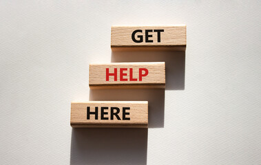 Get help here symbol. Wooden blocks with words Get help here. Beautiful white background. Business and Get help here concept. Copy space.