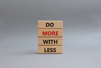 Do more with less symbol. Concept words Do more with less on wooden blocks. Beautiful grey background. Business and Do more with less concept. Copy space.
