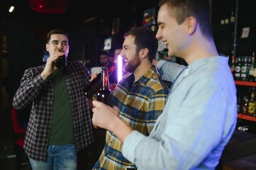 Friends resting in the pub with beer in hands. Having conversation.