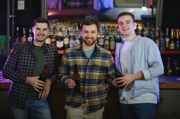 Friends resting in the pub with beer in hands. Having conversation.