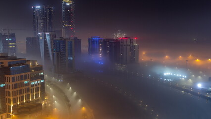 Buildings are covered in thick layer of fog in Business Bay night timelapse.