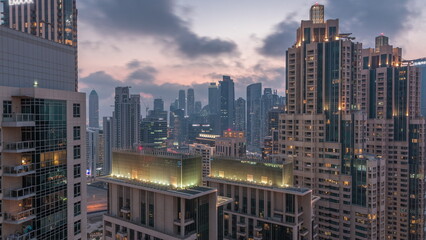 Dubai skyscrapers with golden sky over business bay district day to night timelapse.
