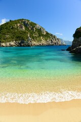 Fototapeta premium Paleokastritsa beah, Corfu island, Greece,- beautiful beach surrounded by cliffs and mountains done to the shore in Spring.