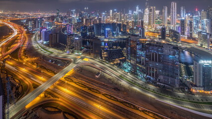 Obraz na płótnie Canvas Panorama showing skyline of Dubai with business bay and downtown district night timelapse.