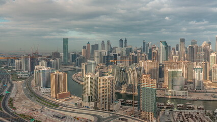Naklejka na ściany i meble Skyline with modern architecture of Dubai business bay towers morning timelapse. Aerial view