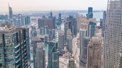 Skyline panoramic view of Dubai Marina showing an artificial canal surrounded by skyscrapers along shoreline all day timelapse. DUBAI, UAE