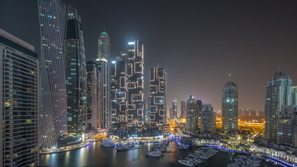 Fototapeta na wymiar Dubai marina tallest skyscrapers and yachts in harbor aerial all night timelapse.