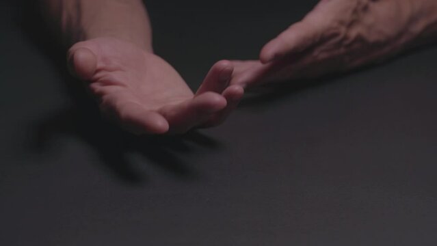 Give me concept. Close-up of two hands adult man showing a demanding gesture give me on a black table. 4K