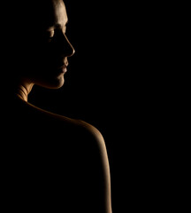 Sensual portrait silhouette of beautiful woman in backlight on a black background