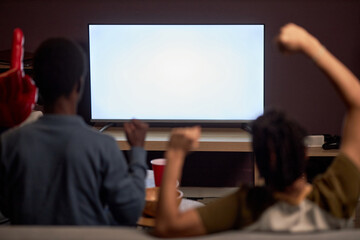 Back view at two excited sports fans watching match on TV with blank screen mockup