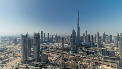 Naklejka na ściany i meble Panorama showing aerial view of tallest towers in Dubai Downtown skyline and highway timelapse.