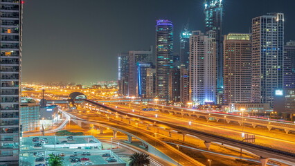 Fototapeta na wymiar Dubai Marina skyscrapers and Sheikh Zayed road with metro railway aerial all night timelapse, United Arab Emirates