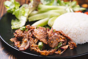 Spicy Grilled Beef or pork and chicken Thai style salad (Red onion, Spring onion, Rice powder, Lettuce Chili powder )in a bowl with rice, called as Nam Tok, Jaew dipping sauce and vegetables