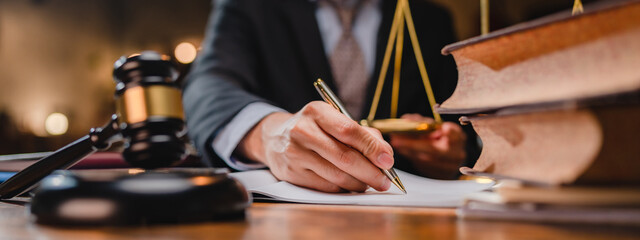 businessman or legal expert reviewing document reports at office workplace with computer laptop, professional lawyer reading and checking financial documents or insurance and sign a contract by pen