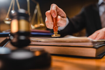 businessman or lawyer put a success stamp on legal deal contract in office, approved on certificate document public paper agreements at desk of notary or business people work to making a signs permit
