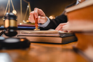 businessman or lawyer put a success stamp on legal deal contract in office, approved on certificate document public paper agreements at desk of notary or business people work to making a signs permit